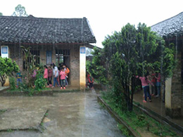 暴雨中，教室里出現(xiàn)漏水情況，學(xué)生們在屋檐下避雨